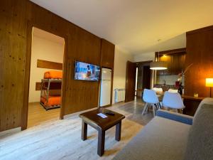 a living room with a couch and a dining room at Apartamentos Los Lagos in Benasque