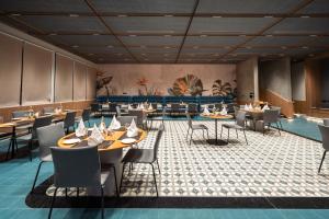 a restaurant with tables and chairs in a room at Orchid Parc Bengaluru - Manyata Business Park in Bangalore