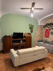 a living room with a white couch and a television at Il Posto delle Rose 2 in San Polo dei Cavalieri