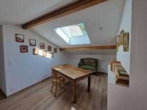 a dining room with a table and a couch at La Ferme Duval in Vaudémont