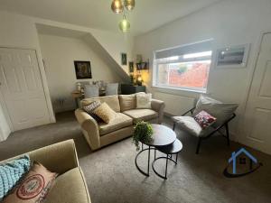 a living room with a couch and a table at 28 Victoria Terrace, Bedlington, ground floor in Bedlington