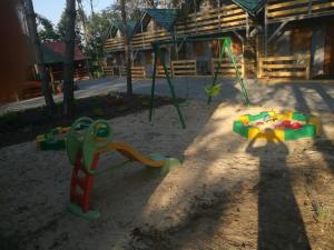 a playground with toys in the sand in front of a house at Domki Piaskowa in Boszkowo-Letnisko