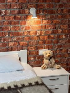 a teddy bear sitting on a table next to a brick wall at Exclusive Apartments "Lviv Vernygory 14", Modern Apartments with Self Check-in in Lviv