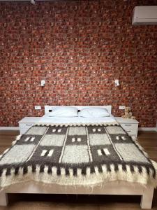 a bedroom with a bed with a brick wall at Exclusive Apartments "Lviv Vernygory 14", Modern Apartments with Self Check-in in Lviv