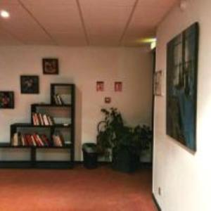a room with a book shelf and a plant at Hôtel de Charme By Arts & Millésimes in Essoyes
