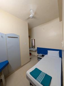 a small room with a bed and a closet at Vinayaka Lodge in Bangalore +2 photos