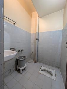 a bathroom with a toilet and a sink at Vinayaka Lodge in Bangalore