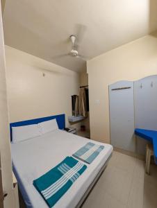 a bedroom with a bed with a blue and white mattress at Vinayaka Lodge in Bangalore