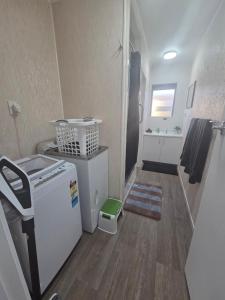a small bathroom with a refrigerator and a sink at Te Whare Whitiora in Hamilton