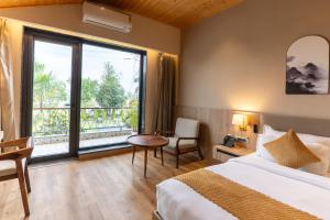 a hotel room with a bed and a large window at Justa Natures Nest Resort in Bullāwāla +75 photos