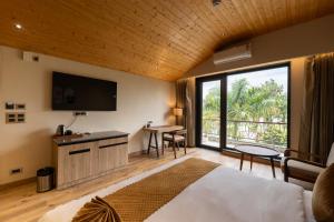 a bedroom with a bed and a television and a table at Justa Natures Nest Resort in Bullāwāla