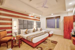 a hotel room with a large bed and a chair at Hotel Vedas Heritage - Karol Bagh - Newly Renovated in New Delhi