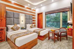 a hotel room with two beds and a table at Hotel Vedas Heritage - Karol Bagh - Newly Renovated in New Delhi