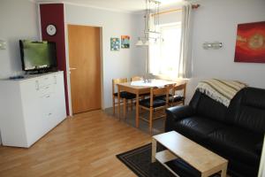 ein Wohnzimmer mit einem Sofa und einem Tisch in der Unterkunft Ferienwohnung Gerda in Zandt