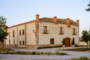an old stone building with a door in front at Palacio de Paradinas in Santa María la Real de Nieva