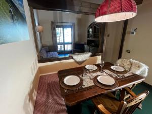 ein Esstisch mit Stühlen und einer roten Lampe in der Unterkunft Sestriere-Sises Lodges, Appartamenti Moderni, vicino alle piste in Sestriere