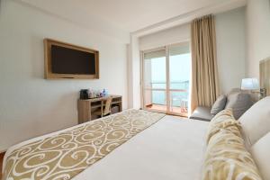 a hotel room with a bed and a television at AluaSun Doblemar in La Manga del Mar Menor