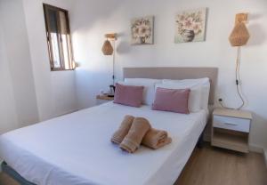a bedroom with a white bed with two towels on it at Hostal San Miguel by Croma in Estepona