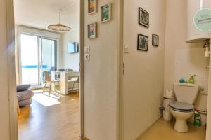 a bathroom with a toilet and a living room at Le Belvédère des Dunes in Saint-Gilles-Croix-de-Vie