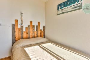 a bedroom with a bed with a wooden headboard at Le Belvédère des Dunes in Saint-Gilles-Croix-de-Vie
