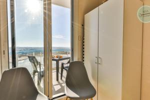 a room with a balcony with chairs and a table at Le Belvédère des Dunes in Saint-Gilles-Croix-de-Vie +12 photos
