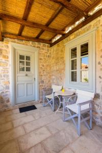 a patio with a table and chairs and a door at Gaia accommodation Hydras in Hydra