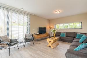 a living room with a couch and a tv at Gerritslanderdijkje 39a in Westermient