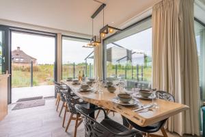 a dining room with a long wooden table and chairs at Gerritslanderdijkje 39a in Westermient +28 photos