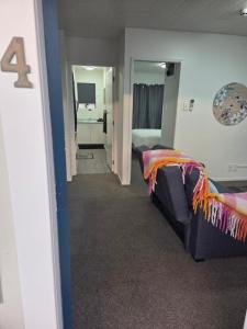 a living room with a couch and a bedroom at Te Whare Whitiora in Hamilton +56 photos