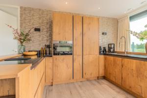 a kitchen with wooden cabinets and a counter top at Gerritslanderdijkje 39a in Westermient
