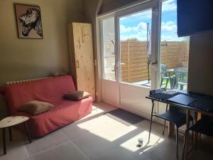 a living room with a red couch and a window at Studio Cosy in Saint-Lon-les-Mines