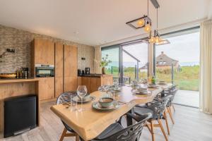 a dining room with a long table and chairs at Gerritslanderdijkje 39a in Westermient