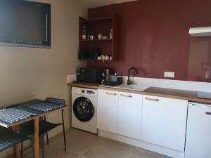 a kitchen with a sink and a washing machine at Studio Cosy in Saint-Lon-les-Mines