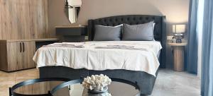 a bedroom with a large bed with a table at Guesthouse Odesos in Sozopol