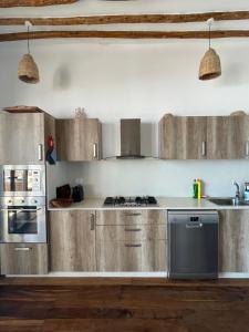 a kitchen with stainless steel appliances and wooden cabinets at Villa Marisella in Kiwengwa