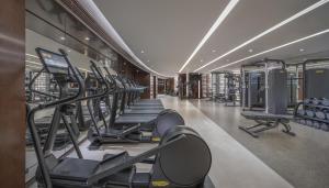 a gym with a row of treadmills and machines at Conrad Hong Kong in Hong Kong +46 photos