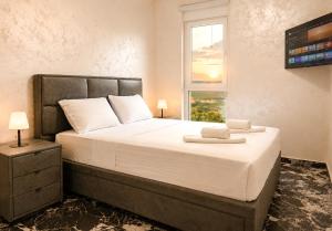 a bedroom with a large bed with a window at Dorado Apartments in Kavač +59 photos