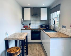 a kitchen with a wooden counter top and a sink at The Lodge Duxford in Duxford
