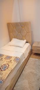 a bed with a padded headboard in a bedroom at Akari said in Rabat