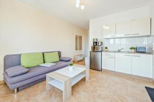 a living room with a purple couch and a kitchen at Ferienwohnung Sonneneck in Kachlin