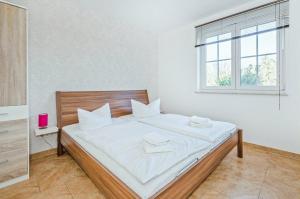 a bedroom with a bed with white sheets and a window at Ferienwohnung Sonneneck in Kachlin