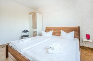 a bedroom with a white bed with two towels on it at Ferienwohnung Sonneneck in Kachlin +3 photos