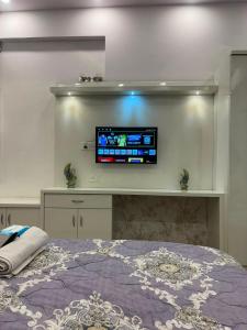 a bedroom with a bed with a tv on the wall at Cozy Crib Stays in Greater Noida