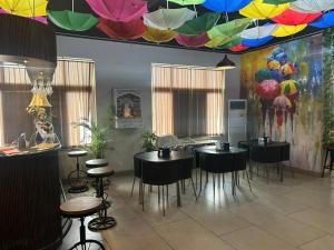 a restaurant with black tables and chairs and a colorful ceiling at Cozy Crib Stays in Greater Noida