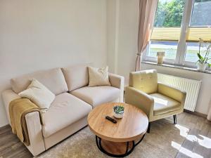 a living room with a couch and a table and a chair at Nicos Ferienwohnung in Grevesmühlen - ABC628 in Grevesmühlen