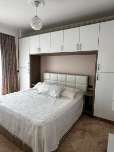 a bedroom with a large bed with white cabinets at Sol & Sea Apartments in Shëngjin +83 photos