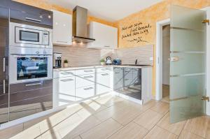 a kitchen with white cabinets and a stove at Ferienhaus Ulme in Kachlin