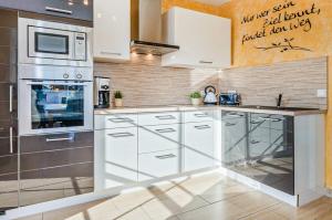 a kitchen with white cabinets and a microwave at Ferienhaus Ulme in Kachlin +9 photos