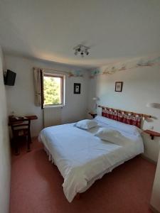 a bedroom with a large white bed and a window at Hôtel Restaurant Le Regimbal in Javols