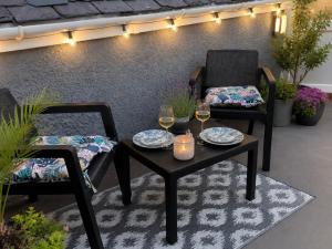 a patio with two chairs and a table with glasses of wine at Tŷ Capel Bach in Bangor